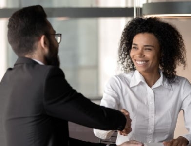 Pitt employees shake hands in an agreement. 